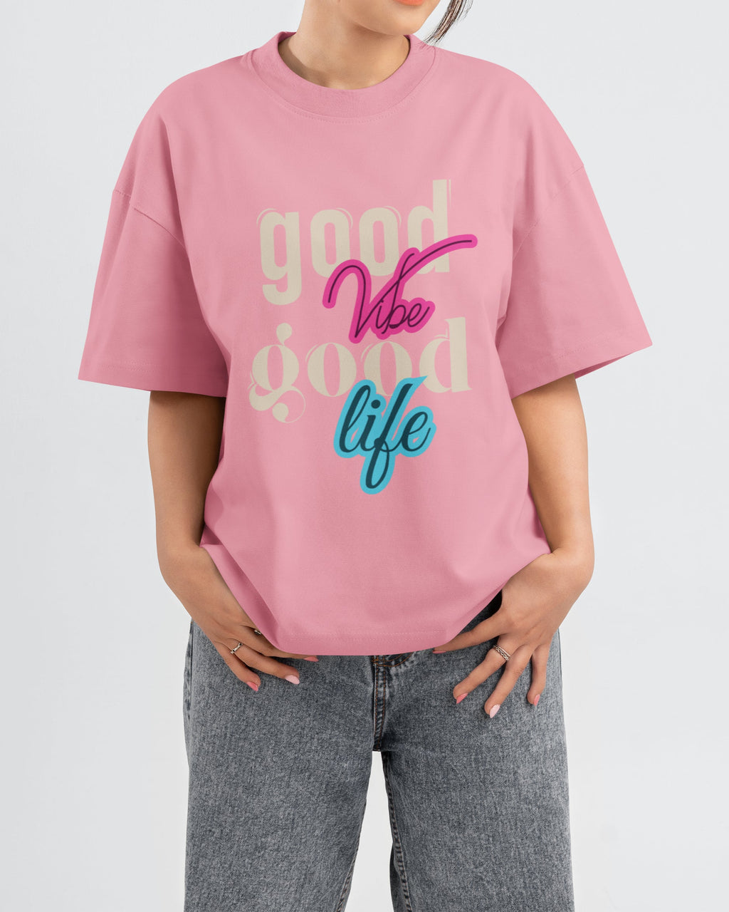 Person wearing a Flamingo t-shirt with 'good vibe good life' text on a plain background