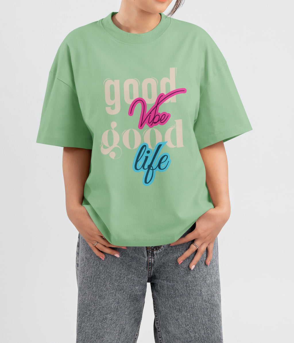 Person wearing a jade_green t-shirt with 'good vibe good life' text on a background