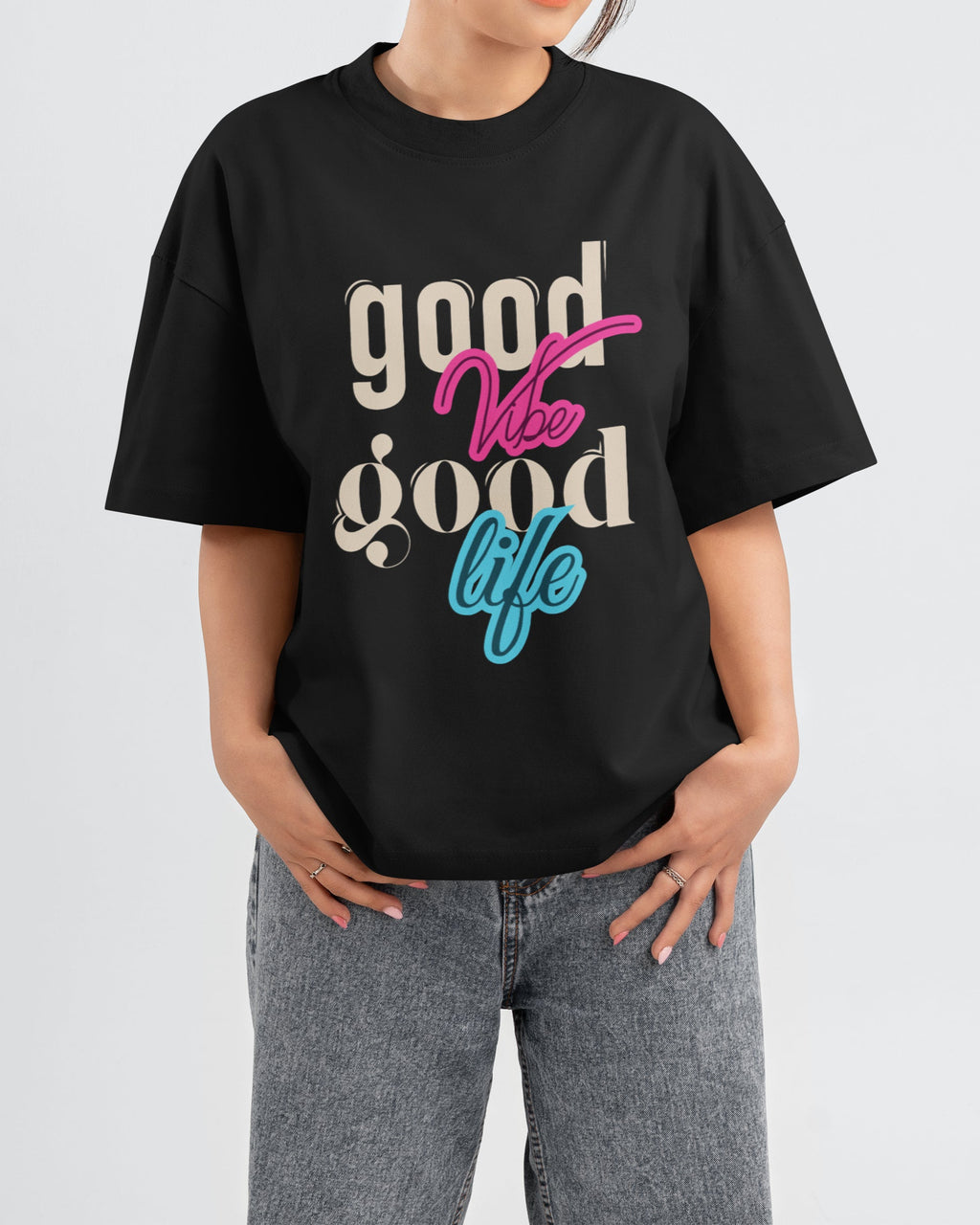 Person wearing a black t-shirt with 'good vibes good life' text on a plain background